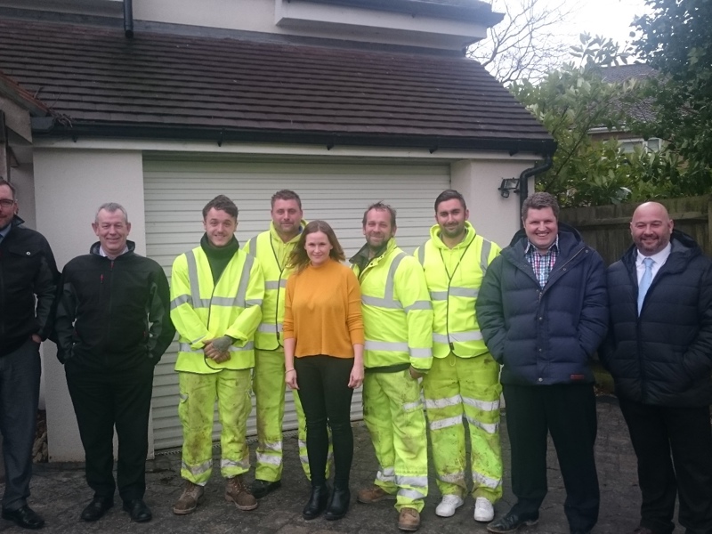 Image of Amey employees stood in a row, in front of a house.