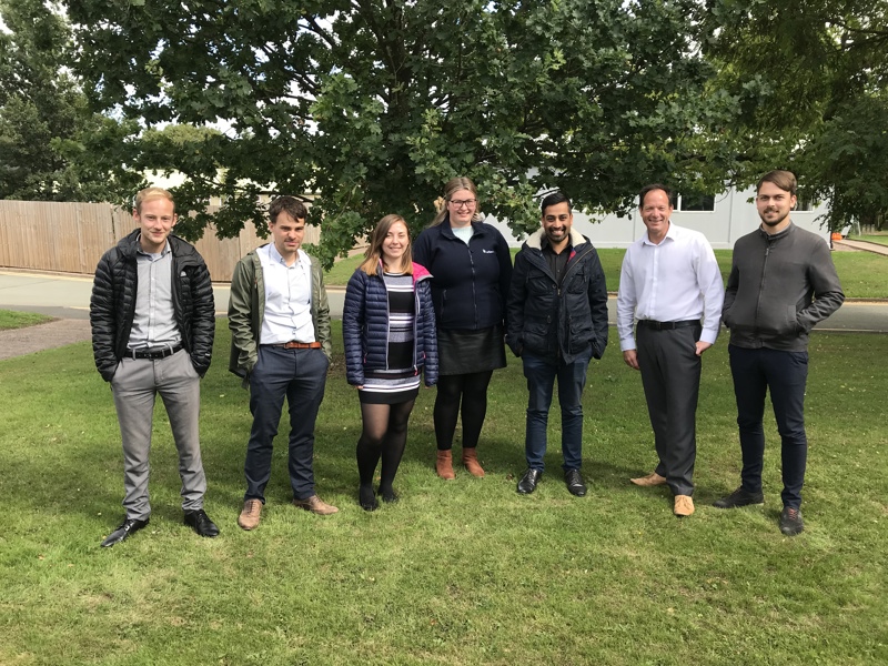 Image of seven Amey employees stood in a line on a grassed area.