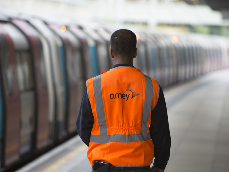 Image of Amey employees, wearing PPE stood at a rail platform.