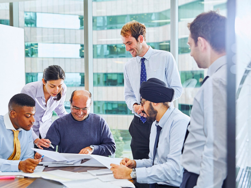 A group of people working round a desk.