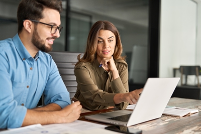 Image of two work colleagues looking at laptop
