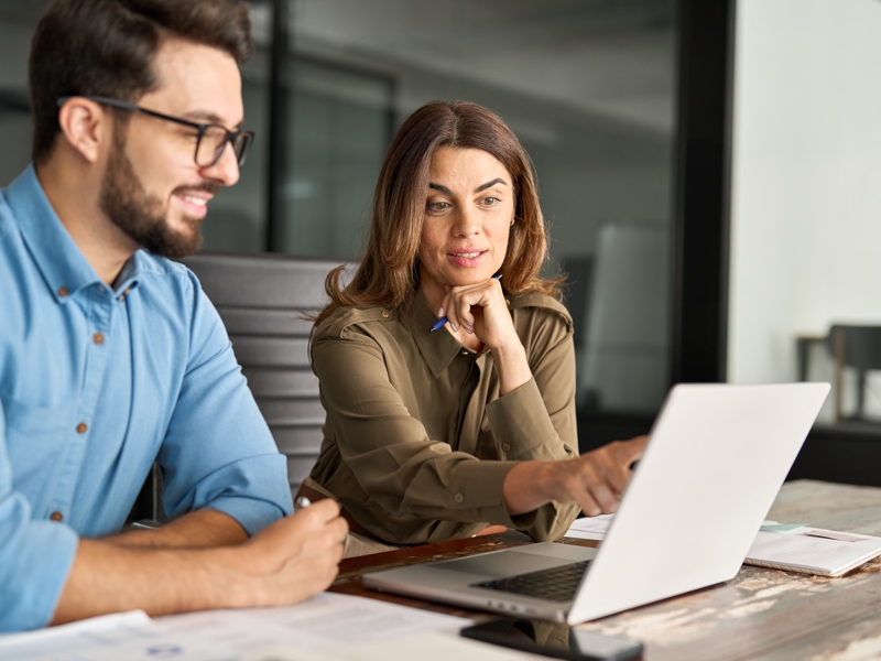 Image of two work colleagues looking at laptop