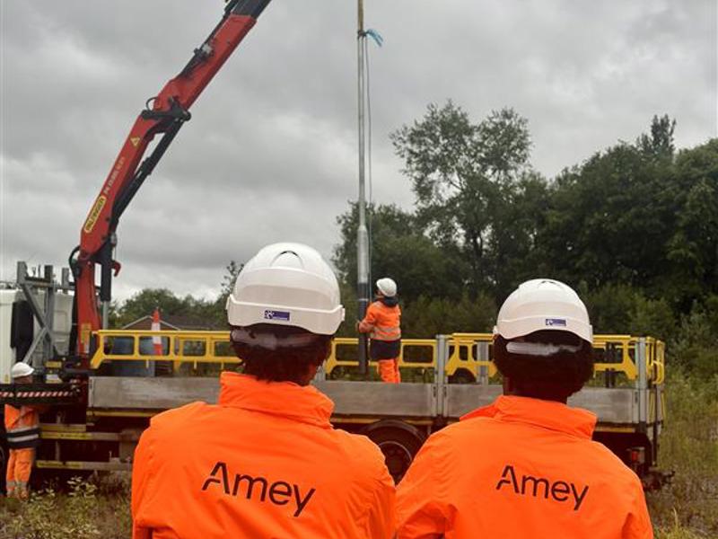 Two people in PPE, stood in front of a crane.