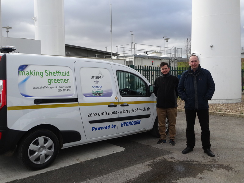 Two men stood next to a van.