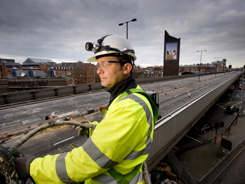 A man in PPE carrying out bridge repairs.