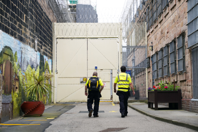 Image of Amey employees walking towards prison gates