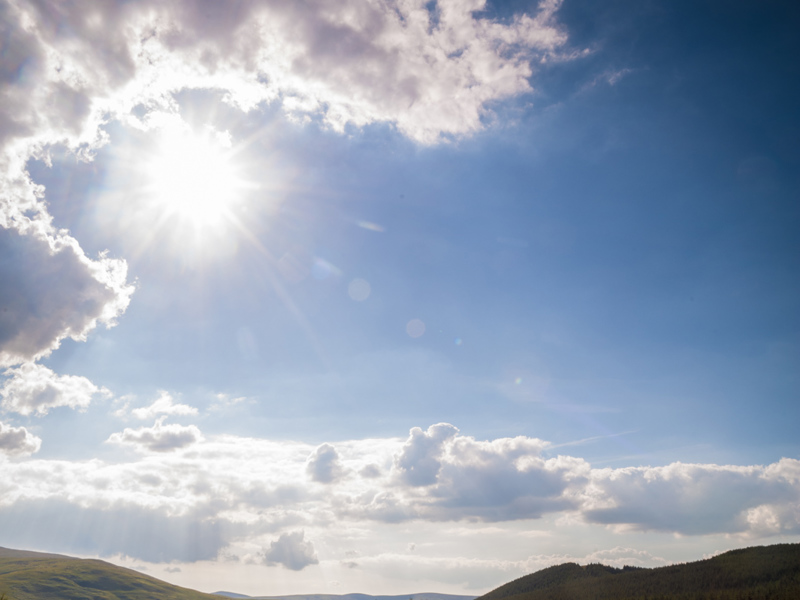 Image of a road, with a blue sunny sky.
