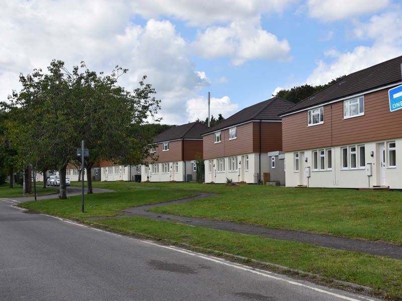 Image of houses in a row, with grass out the front.