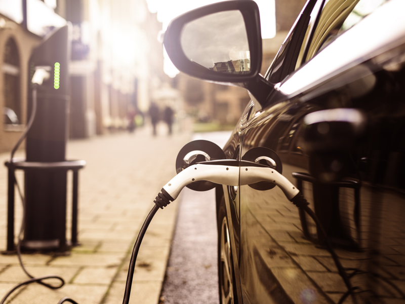 Up close image of an electric vehicle being charged.