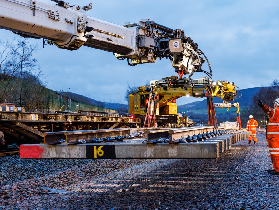 a crane placing a rail track on the ground