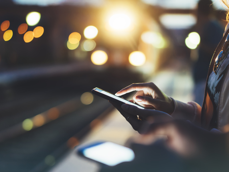 man on his phone at a train platform