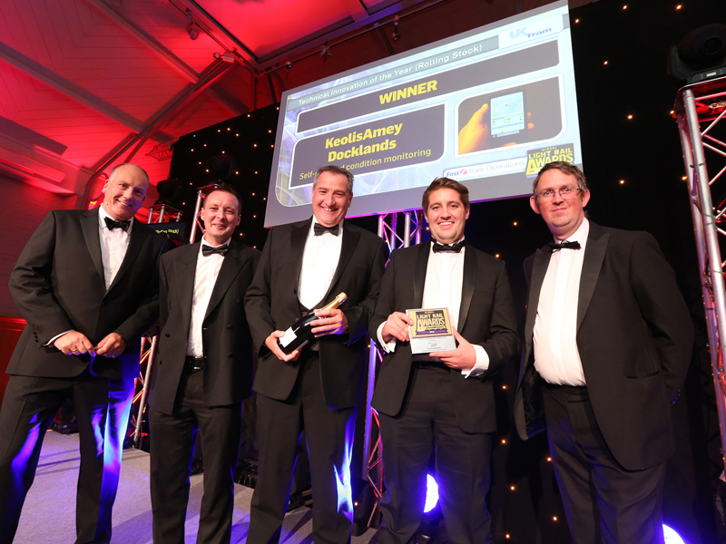 men in formal attire, holding an award.