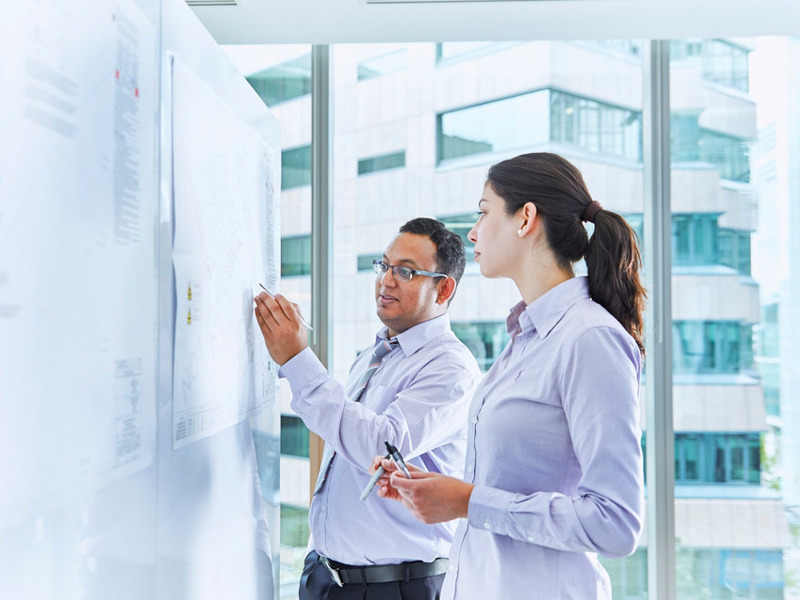 Image of two people collaborating on a whiteboard.