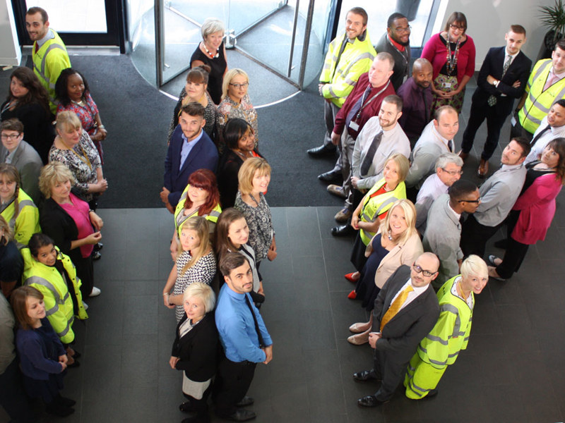 A group of Amey employees stood in back to back lines in the office.