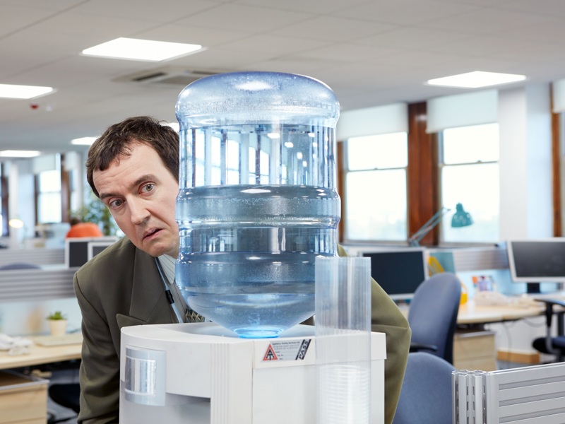 a man behind a water dispencer. 