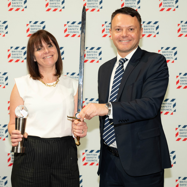 Image of two Amey employees holding an award and a sword.