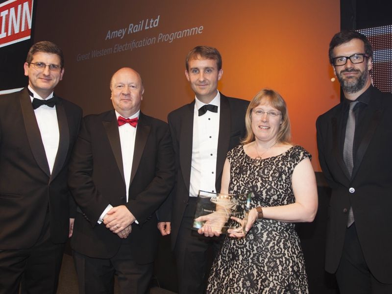 Amey employess in formal attire, holding an award.