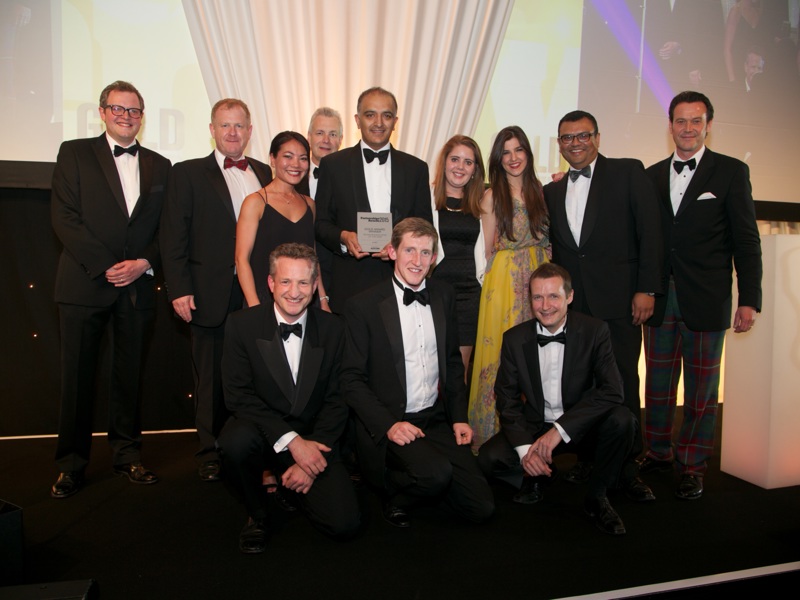 A group of Amey employees, in formal attire, holding an award.