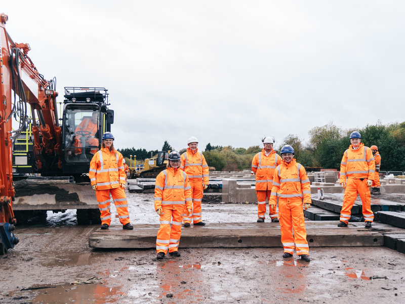 A group of people in PPE, on a construction site.