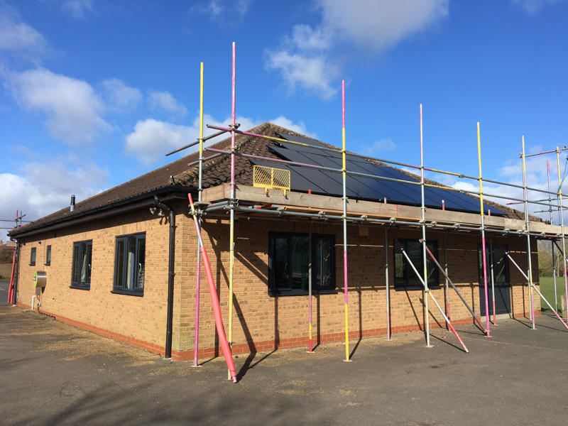 Image of a roof with solar panels and scaffolding. 