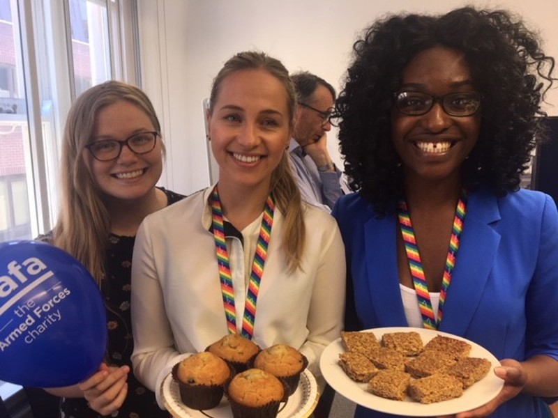 Image of Amey employees holding cakes at a charity event.
