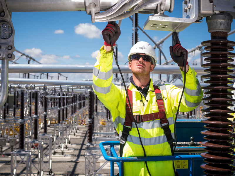 Amey employee in PPE and a safety harness, working at height.