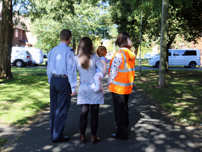 Image of a military family and Amey employee with their backs to the camera.