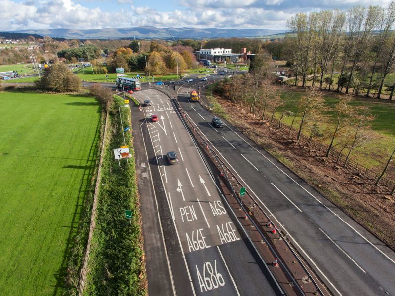Image of a highway, approaching a roundabout 