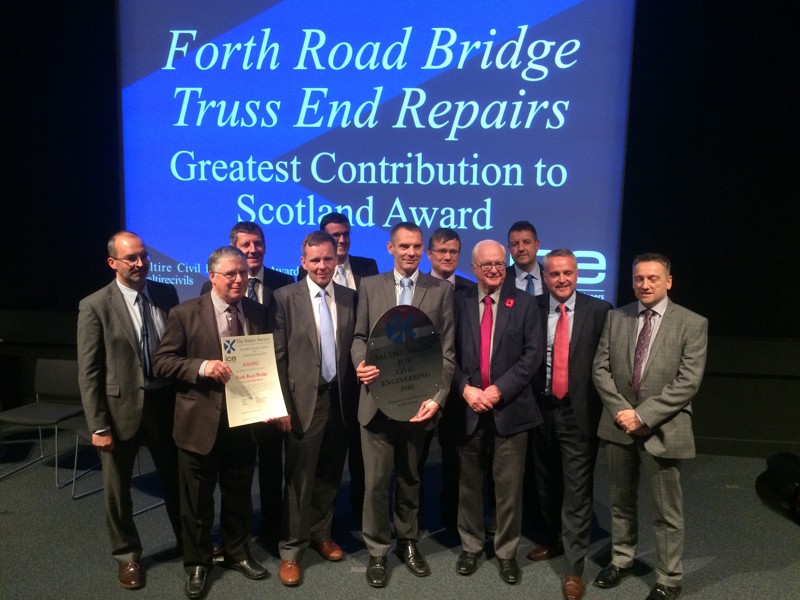 A group of Amey employees, in formal attire, holding an award.