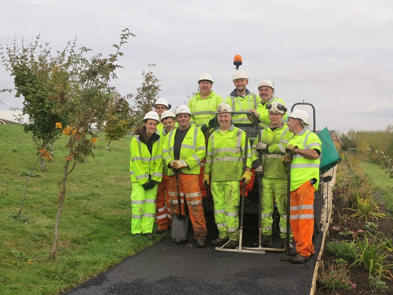 Image of Amey employees in PPE, holding tools.