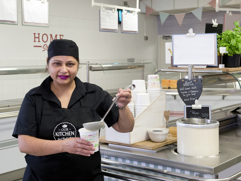 Image of a lady serving soup.