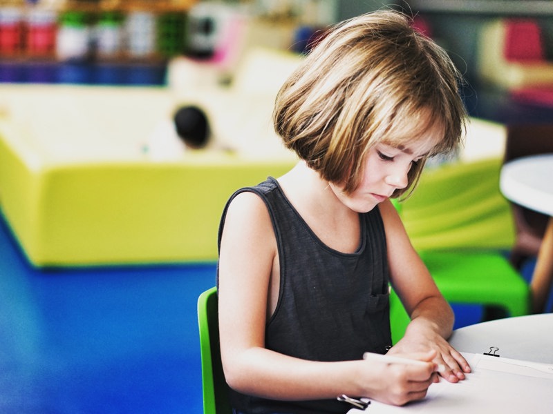 School child sat at a desk.