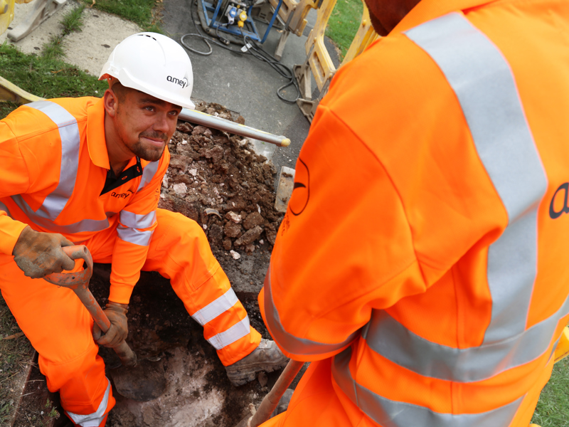 Two men in PPE, carrying out maintenance work.