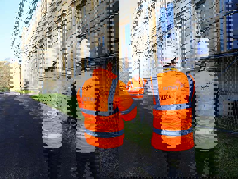 Image of Amey employees in PPE stood in front of a building with scaffolding.