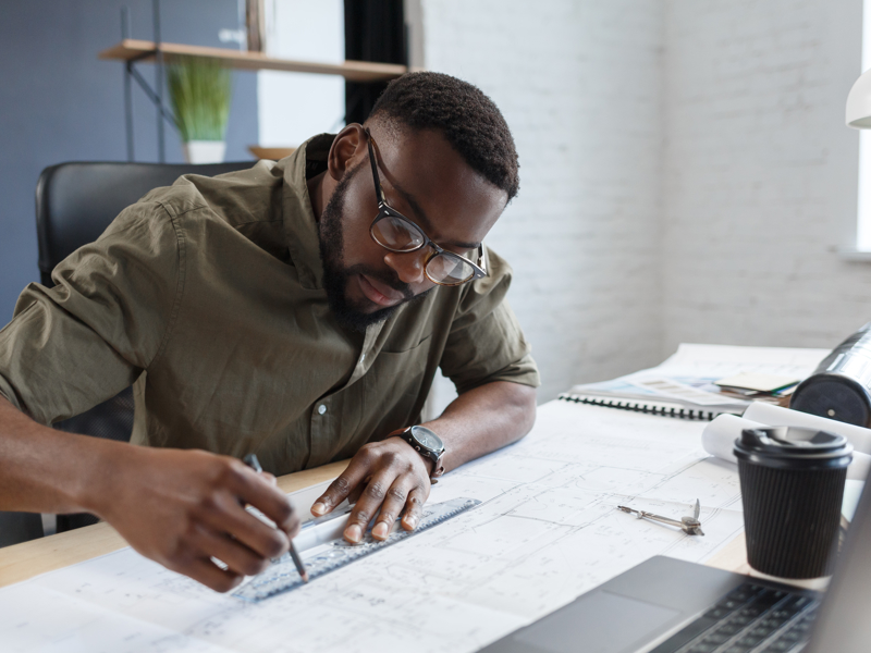 image of a man drawing a line with a ruler as a desk.