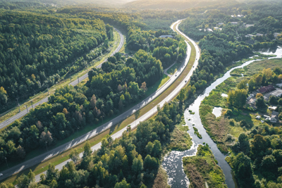 Image of rail and road infrastructure working it's way through a forested area