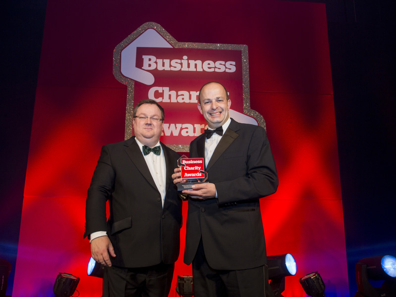 Image of David Fawcett holding an award for Business charity.