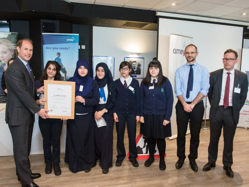 Image of school children and Amey employees holding a certificate.