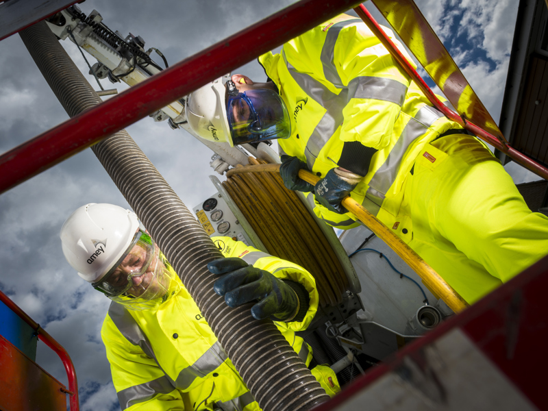 Two Amey employees in PPE, carrying our work.