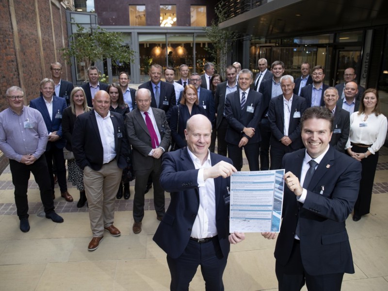 Group image of Amey employees, celebrating holding a document.