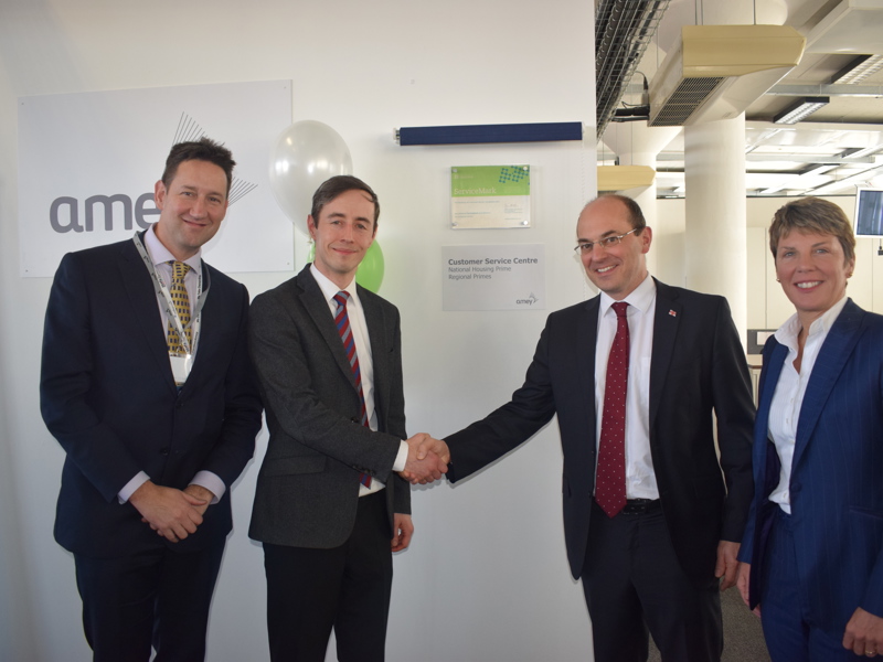 Four people in an Amey office, two are shaking hands.