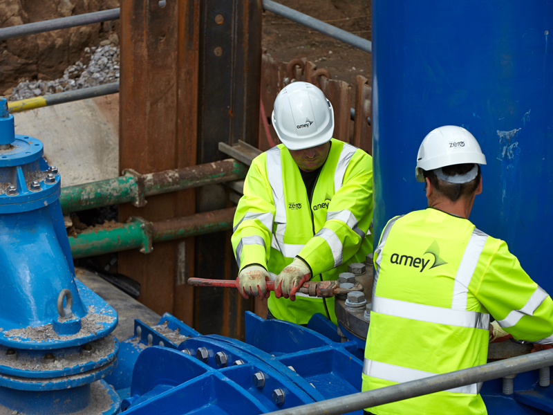 Two men in PPE, carrying out maintenance work.