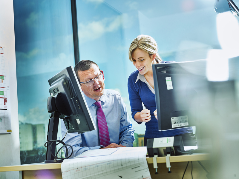 Image of two workers at a desk.