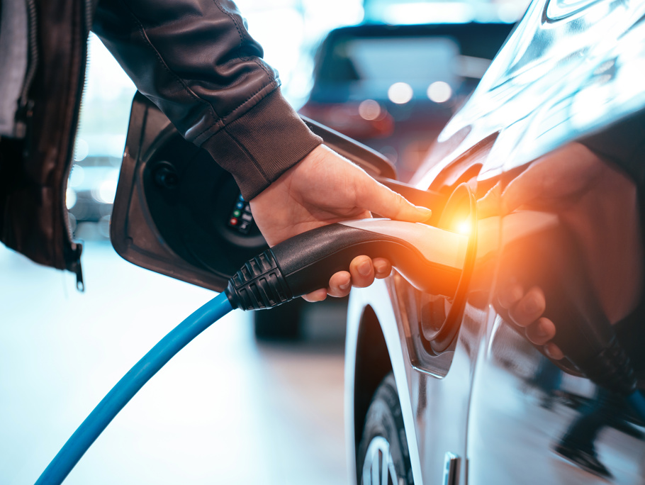 Image of a man placing a charger in an electric car.
