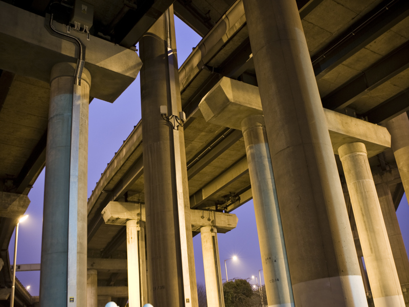 Two Amey employees, wearing PPE, inspecting a column. 