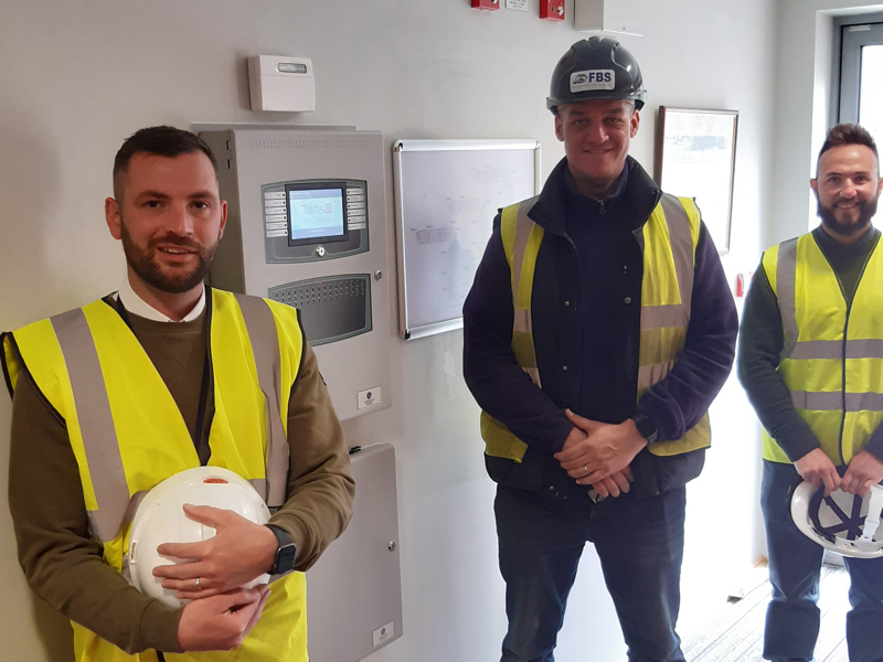 Image of three Amey employees in PPE stood in a hallway.