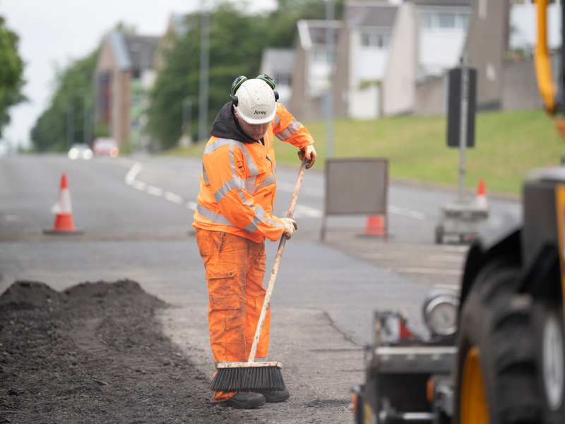 man in PPE working at the side of a road