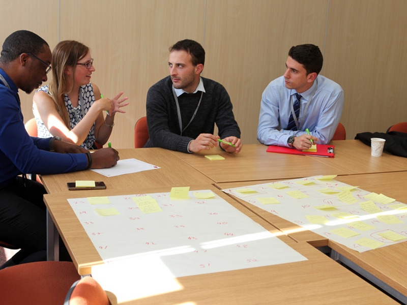 Four people sat at a corner of a table.
