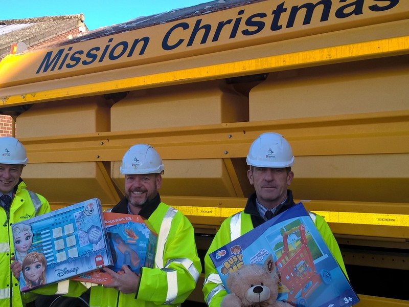 Image of men in PPE holding children's toys.