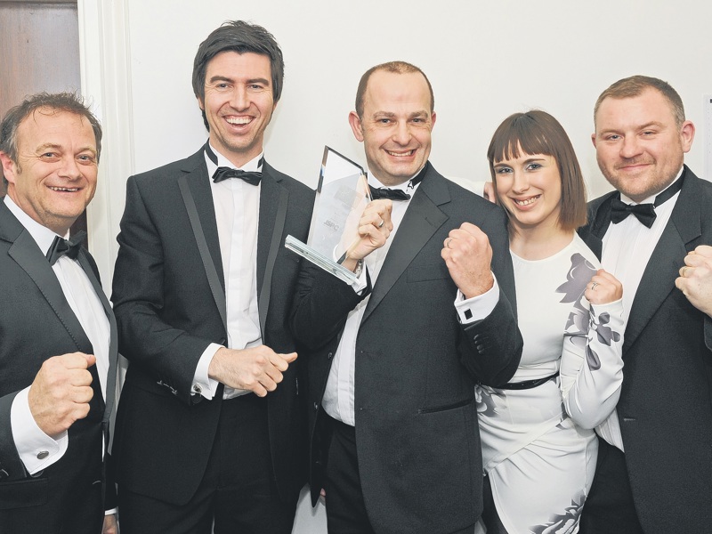 Amey employees in formal attire, holding a New Business Excellence award.